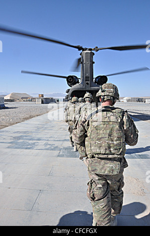 LOGAR PROVINCE, Afghanistan – Soldiers participating in the reenlistment ceremony for Sgt. 1st Class Jeremy K. Schwanke board the Ch-46 Chinook helicopter prior to his reenlistment. Schwanke, a native of Newport News, Va., is the military police operations sergeant for the 3rd Brigade Combat Team, 1st Armored Division is deployed from Fort Bliss, Texas to Forward Operating Base Shank. The 2nd Aviation Battalion, 82nd Combat Aviation Brigade, known as Task Force Corsair provided the helicopter for the event. Stock Photo