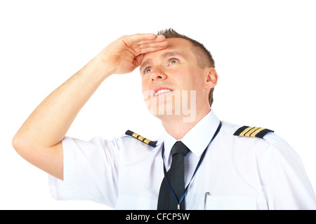 Cheerful airline pilot wearing uniform with epauletes looking upwards, isolated on white background. Stock Photo