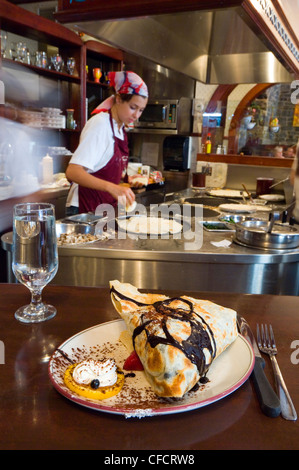 Woman preparing crepes at restaurant in popular Latin quarter along rue St. Jean, Quebec City, Quebec, Canada. Stock Photo