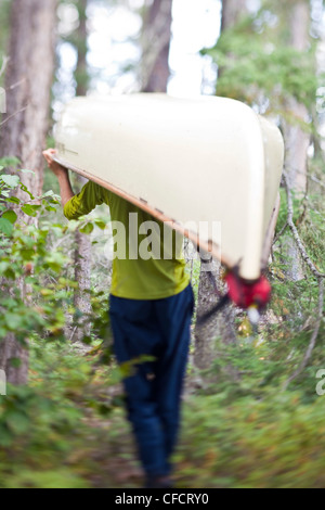 A man portages his canoe through Wabakimi Provincial Park, Ontario, Canada Stock Photo