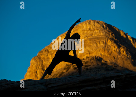 A fit young woman practicing yoga while on a rock climbing trip, Red Rocks, Las Vegas, Nevada, United States of America Stock Photo