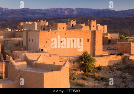 Kasbah bathed in evening light with the Jbel Sarhro Mountains in the distance, Nkob, southern Morocco, Morocco, North Africa Stock Photo
