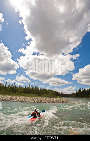 A middle aged man surfs the rapids in his kayak on the Red Deer River, Alberta, Canada Stock Photo