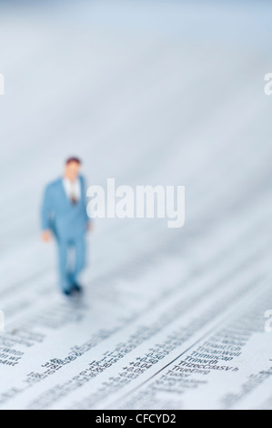 Miniature businessman figurine on stock quotations newspaper Stock Photo