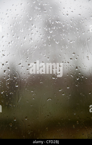 Raindrops on glass window pane looking out Stock Photo