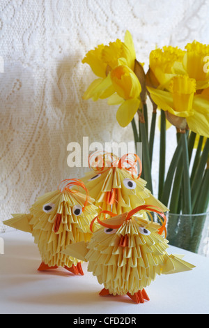 cute origami chicks ready for Easter with daffodils in the background Stock Photo