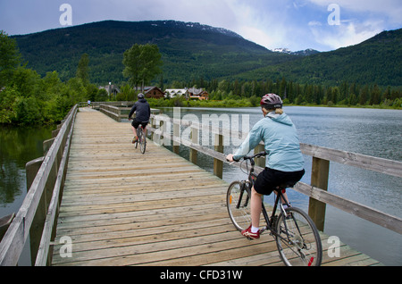 Cyclists on Green Lake boardwalk, Whistler, British Columbia, Canada Stock Photo