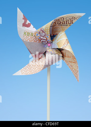 British Pound banknote cut into toy windmill shot on blue background Stock Photo