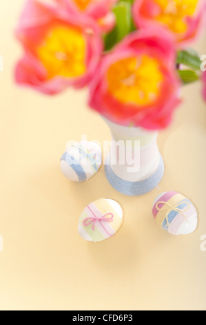 Pink tulips, Easter eggs and handmade yarn wrapped bottle Stock Photo
