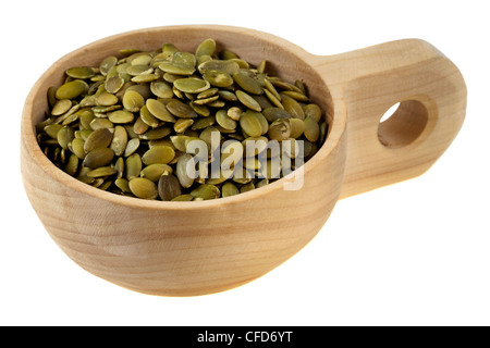 roasted pumpkin seeds (pepita) in a rustic wood cup (scoop), isolated on white Stock Photo