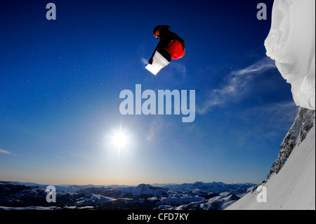 A snowboarder soaring in the air at sunrise in the Sierra Nevada mountains near Lake Tahoe, California. Stock Photo