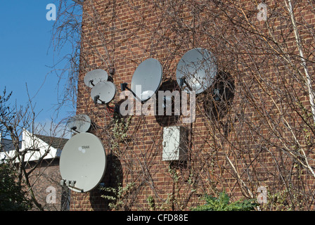 grouping of large and small satellite dishes on the side of block of flats in wandsworth, southwest london, england Stock Photo