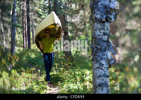 A man portages his canoe through Wabakimi Provincial Park, Ontario, Canada Stock Photo