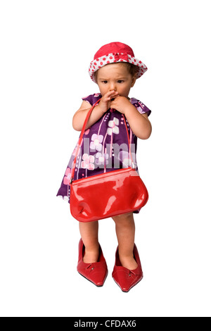 Funny fashion shoot with cute one year old girl wearing a big oversized shoes, isolated on white background. Stock Photo