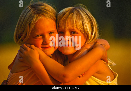 Portrait of two girls hugging outdoors Stock Photo - Alamy