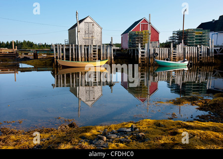 Dories reflected in water at low tide, Blue Rocks, Lunenburg, Nova Scotia, Canada Stock Photo