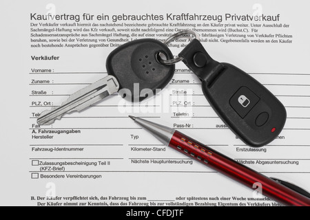 Detail photo of a car sales agreement in German, alongside are car key and a pen Stock Photo