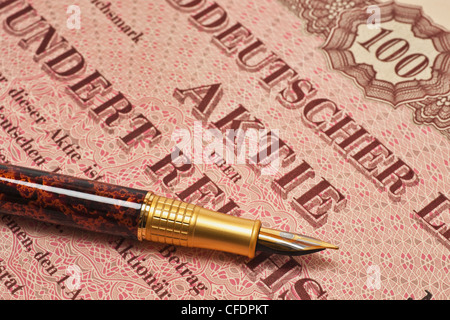 Teilansicht einer alter Aktie, ein Füllfederhalter liegt dabei | partial view of an old share and a fountain pen Stock Photo