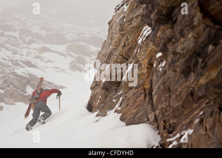 A middle aged man bootpacks up the famous Aemmer coulior on Mt Temple, Lake Louise, Banff National Park, Alberta, Canada Stock Photo