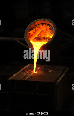 Foundry - molten metal poured from ladle into mould - lost wax casting Stock Photo