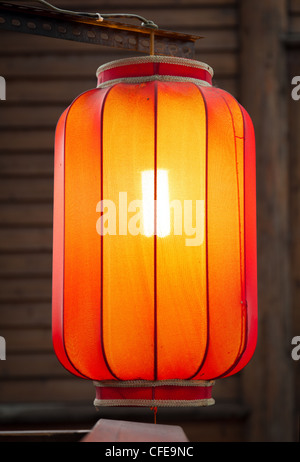 Hanging red lantern on the traditional wooden wall background Stock Photo