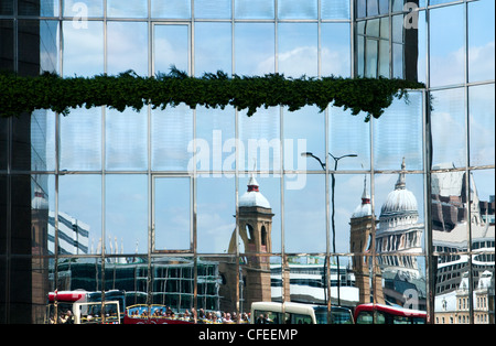 Reflections of St Paul's cathedral and Cannon Street railway station in the glass frontage of Number One London Bridge. Stock Photo