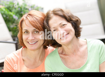 Family portrait of smiling mature mother and daughter Stock Photo