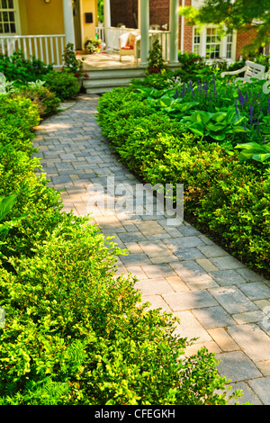 Paved stone path in lush green home garden Stock Photo