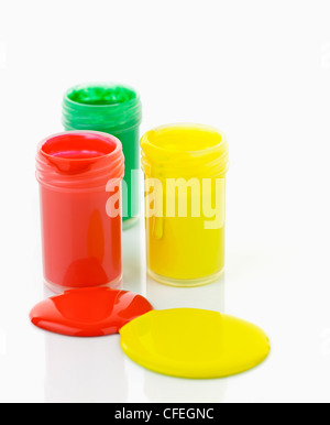 Open containers of paint in primary colors spilled and mixed Stock Photo
