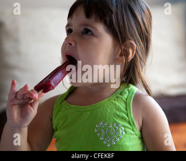 Girl enjoying red ice lolly Stock Photo
