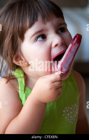 Girl enjoying red ice lolly Stock Photo