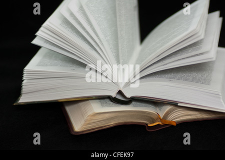 Two open books isolated on black background. Stock Photo