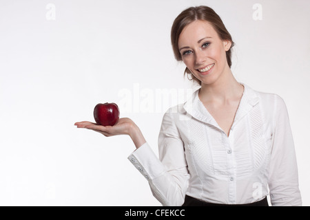 Young female presenting a red apple Stock Photo