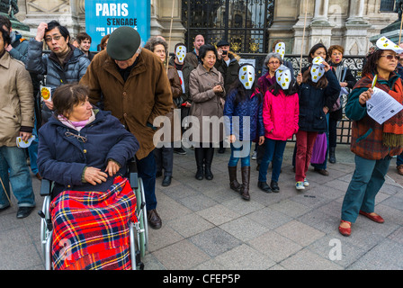 Paris, France, Anti Nuclear Power Activists Demonstrating on Anniversary of Fukushima Disaster, Handicapped WOman in Wheelchair, special needs access, People standing up in a crowd Stock Photo