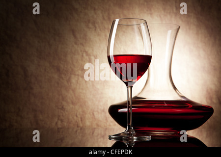 decanter with red wine and glass on a old stone background Stock Photo