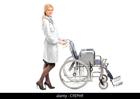 Full length portrait of a healthcare professional pushing a wheelchair isolated on white background Stock Photo