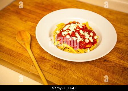 A bowl of mostaccioli Pasta with tomato sauce topped with feta cheese Stock Photo
