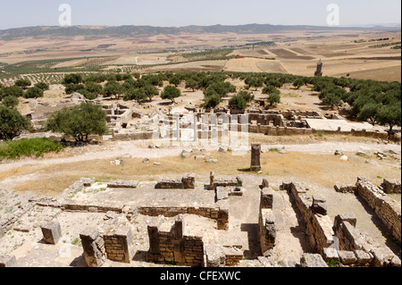 Dougga. Tunisia. View over ruins of houses to the mid photo remains of the House of the Trefoil and Baths of Cyclops. In the Stock Photo