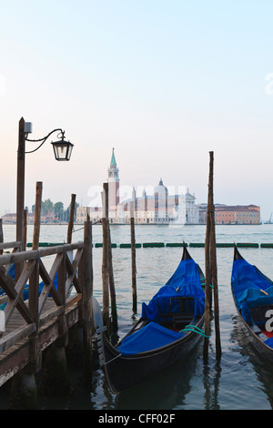 Gondolas moored on the Lagoon, San Giorgio Maggiore beyond, Riva degli Schiavoni, Venice, Veneto, Italy Stock Photo