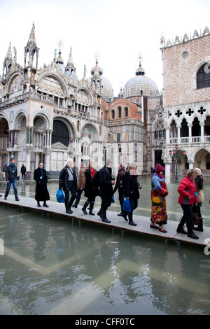 Tourists walking on footbridges during high tide in St. Mark's Square, Venice, UNESCO World Heritage Site, Veneto, Italy, Europe Stock Photo