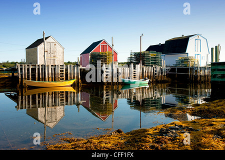 Dories reflected in water at low tide, Blue Rocks, Lunenburg, Nova Scotia, Canada Stock Photo