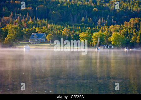 View of fog lifting on Baddeck Bay, Bras D'Or Lake, Cape Breton, Nova Scotia, Canada Stock Photo