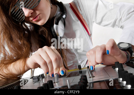 Young disc jockey girl crossfading tracks on professional mixing controller Stock Photo