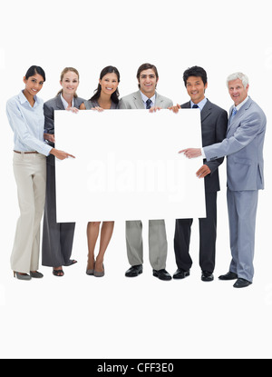 Smiling multicultural business team holding and showing a placard Stock Photo