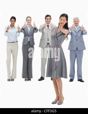 Woman doing a wink with a business team with their thumbs-up Stock Photo