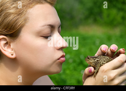 woman kissing a toad Stock Photo