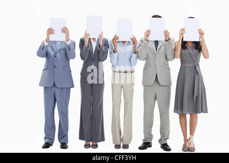 Five business people hiding their faces behind small placards Stock Photo