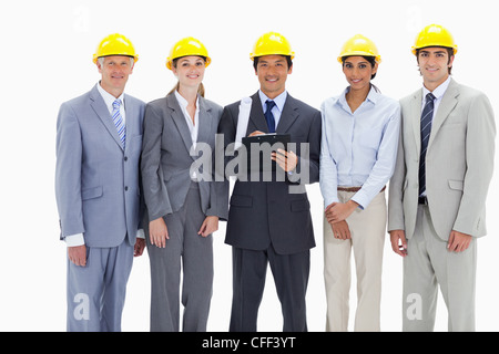 Close-up of an architect surrounded by smiling business people Stock Photo