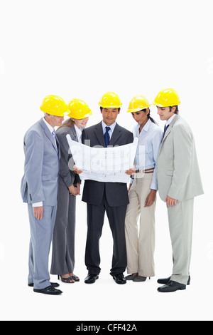 Business people wearing safety helmets watching a construction plan Stock Photo