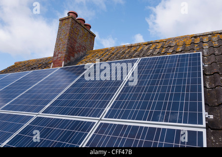 Solar panels fitted to the tiled roof of a UK home. Stock Photo